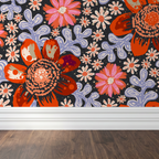 Bold floral wallpaper with red and pink flowers on black background in room setting.