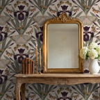 Botanical wallpaper with purple irises and moths on beige, ornate mirror, vintage decor.
