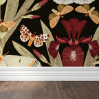 Charcoal wallpaper with burgundy irises and earthy moths in a living room setting.