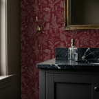 Crimson botanical wallpaper with intricate plant drawings in a vintage bathroom setting.
