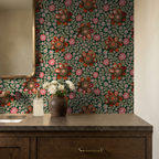 Floral wallpaper with orange and pink flowers on dark green in bathroom setting.