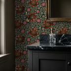 Floral wallpaper with orange and pink flowers on emerald backdrop in bathroom setting.