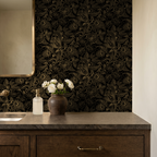 Gold and black floral wallpaper in elegant bathroom setting with wooden vanity.