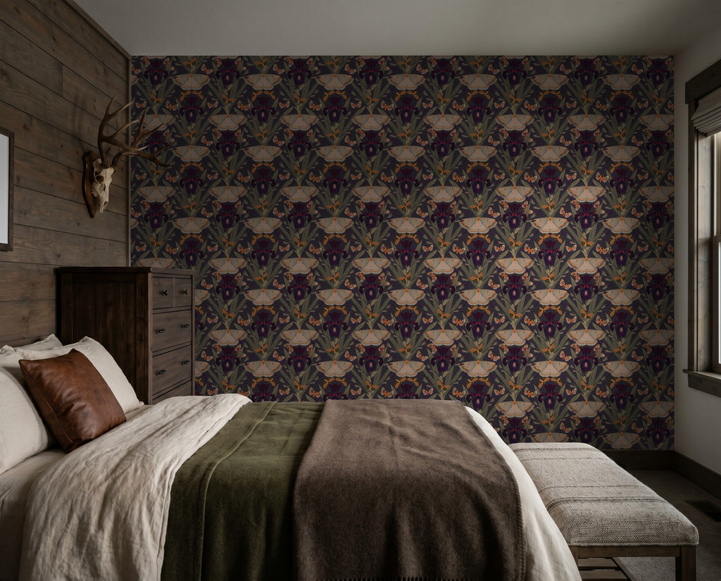 Moody floral wallpaper with moths and irises in a rustic bedroom setting.