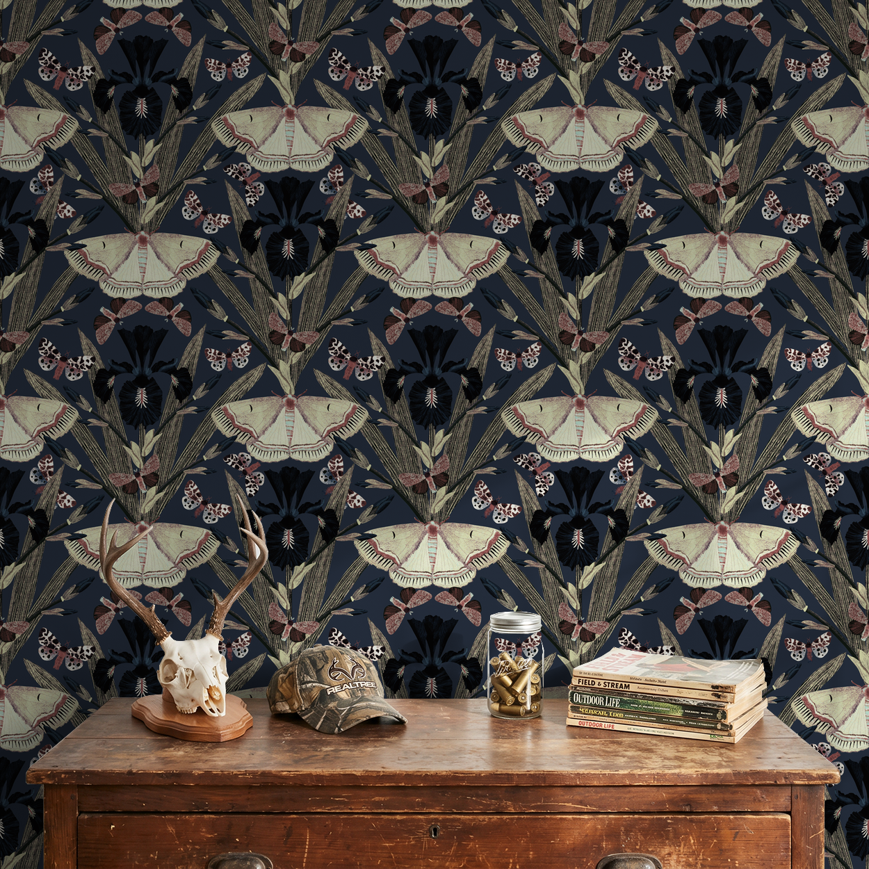 Moth and iris floral wallpaper in dark tones with vintage decor setting.
