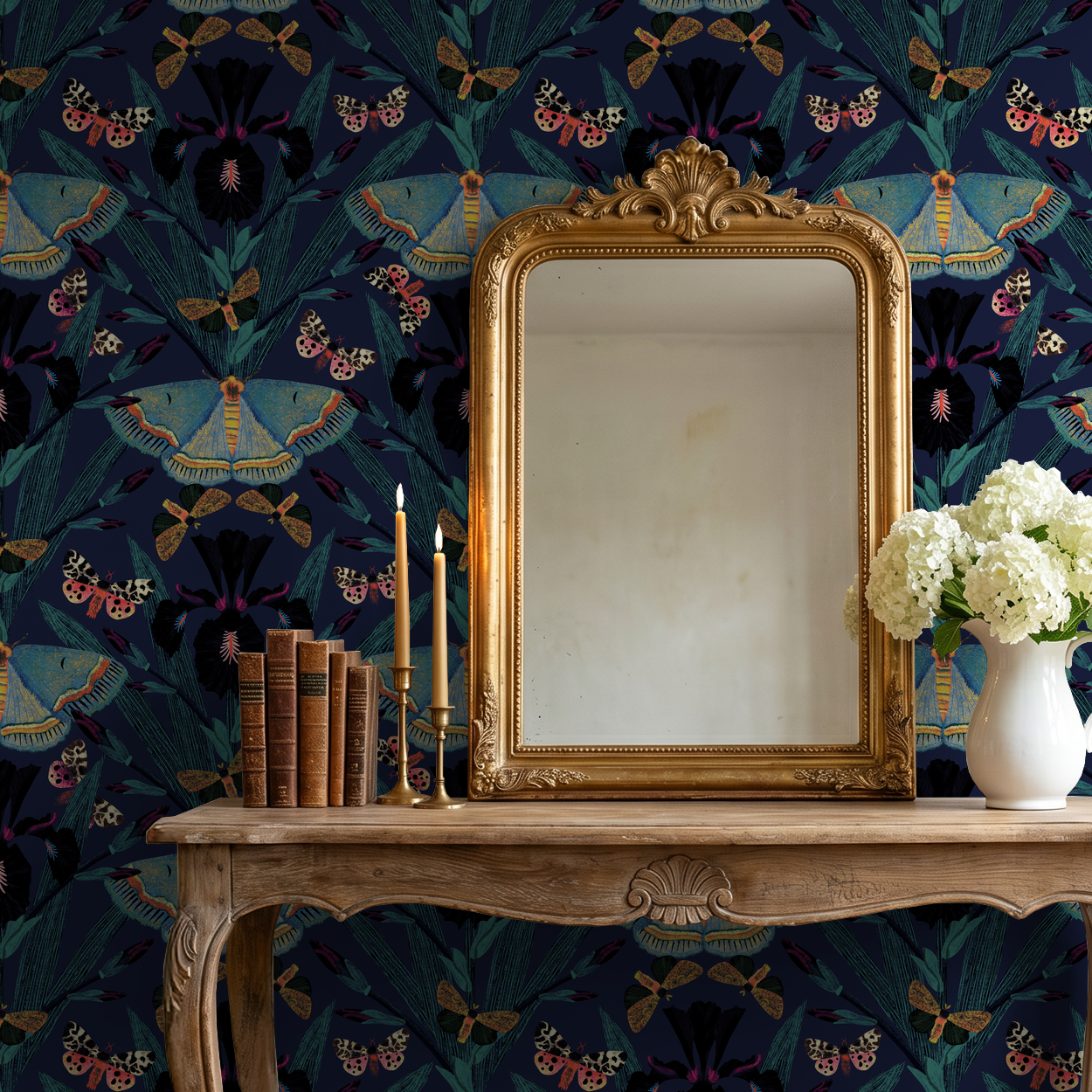 Navy wallpaper with moths and irises behind ornate mirror and candles