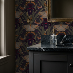Olive wallpaper with moths and Dutch irises in a bathroom with dark vanity.