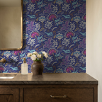 Pink and blue floral wallpaper in bathroom with wooden vanity